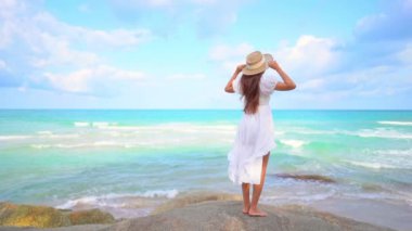 Güzel Asyalı kadının yaz tatilinde deniz kıyısında dinlendiği görüntüler.