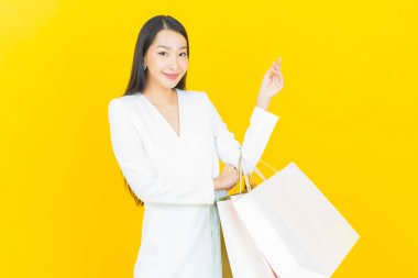 Portre güzel Asyalı kadın tebessümü ile renk arka planında alışveriş torbası