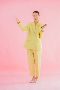 Güzel Asyalı iş kadını portresi. Arka planda kahve fincanı ve akıllı cep telefonu kullanıyor.