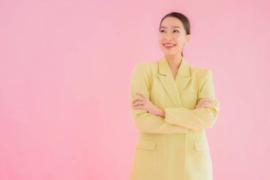Portre güzel Asyalı genç iş kadını pembe arka planda gülümsüyor