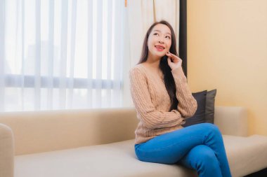 Güzel bir Asyalı kadın portresi rahatla. Gülümse. Yatak odasının iç dekorasyonunda mutlu ol.