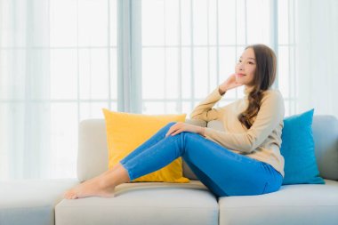 Güzel bir Asyalı kadın portresi. Rahat ol. Oturma odasının iç kısmındaki kanepede keyfine bak.