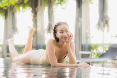 Güzel bir Asyalı kadın portresi. Rahatlayın. Yüzme havuzu etrafında gülümseyin.