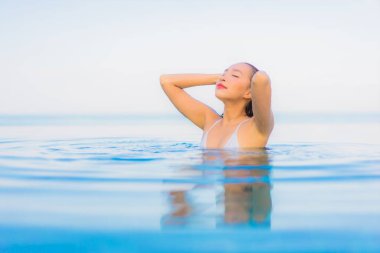 Güzel bir Asyalı kadın portresi. Rahat ol. Yüzme havuzu etrafında gülümse.