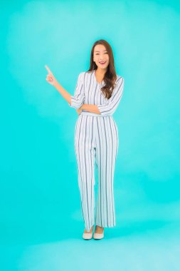 Asyalı güzel bir kadının portresi mavi izole edilmiş arka planda gülümsüyor.