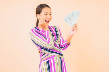 Parası, parası ve cep telefonu olan güzel Asyalı bir kadının portresi.