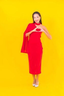 Güzel bir Asyalı kadın portresi. Sarı izole edilmiş arka planda hareketli gülümsüyor.