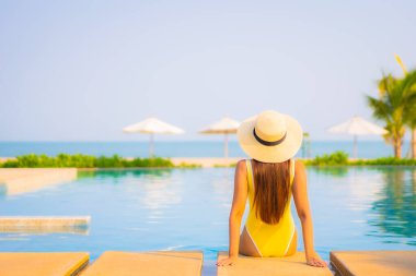 Güzel bir Asyalı kadın portresi. Rahatlayın, gülümseyin. Tatil için oteldeki yüzme havuzunun keyfini çıkarın.