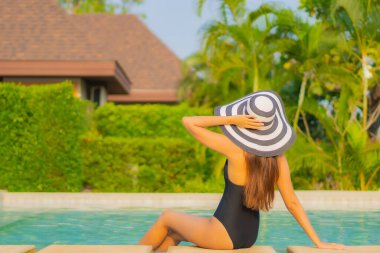 Güzel bir Asyalı kadın portresi. Rahatlayın, gülümseyin. Tatil için oteldeki yüzme havuzunun keyfini çıkarın.