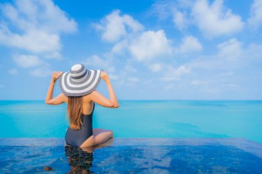 Güzel bir Asyalı kadın portresi. Rahatlayın. Okyanus manzaralı, tatil köyündeki yüzme havuzunda rahatlayın.