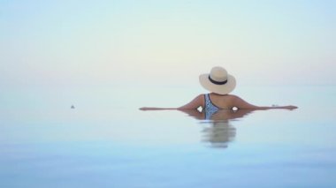 Güzel, genç Asyalı bir kadının dinlenme, dinlenme, deniz kenarında yüzme havuzu, tatil için deniz kenarında yüzme görüntüsü.