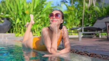 Güzel, genç Asyalı bir kadının dinlenme, dinlenme, deniz kenarında yüzme havuzu, tatil için deniz kenarında yüzme görüntüsü.