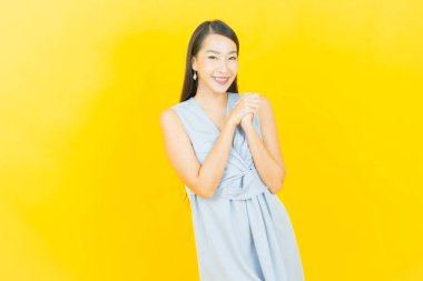 Portre güzel Asyalı kadın gülümsüyor. Renkli arka planda hareket var.