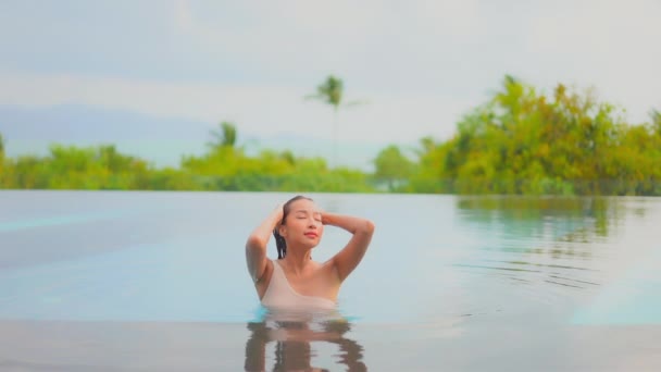 아름다운 이시아 휴가를 즐기기 해변의 바닷가 수영장에서 한가롭게 — 비디오