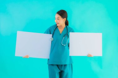Fotokopi için boş kâğıt tahtası olan güzel Asyalı genç doktor kadın hastane ve klinikteki sağlık hizmetleri konseptinde mavi izole edilmiş arka plan.