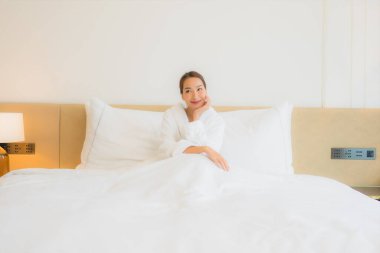 Güzel bir Asyalı kadın portresi. Rahatlayın, gülümseyin. Yatak odasında dinlenin.