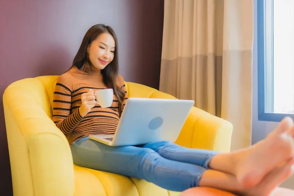 在客厅的沙发上 年轻美丽的亚洲女人在活动时放松地微笑 — 图库照片