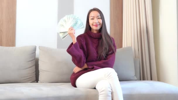Záběry Krásné Asijské Ženy Držící Hromadu Peněz Gauči Doma — Stock video