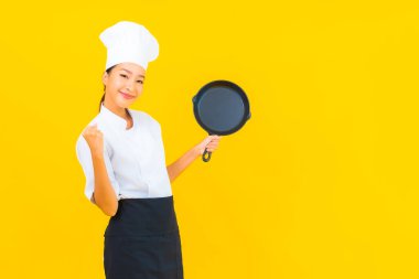 Sarı izole arka planda siyah şapkalı güzel Asyalı şef kadın portresi.
