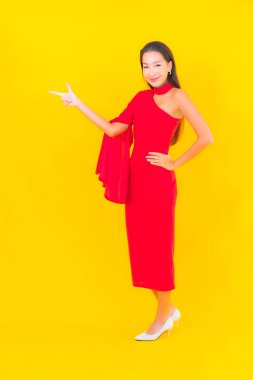 Güzel bir Asyalı kadın portresi. Sarı izole edilmiş arka planda hareketli gülümsüyor.