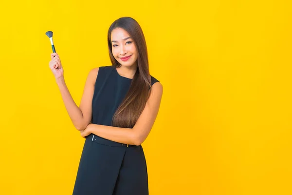 노란색 화장품 사용하는 아름다운 아시아 사업가의 — 스톡 사진