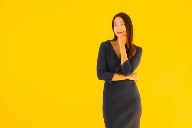 İzole edilmiş sarı arka planda hareketli güzel Asyalı kadın portresi.