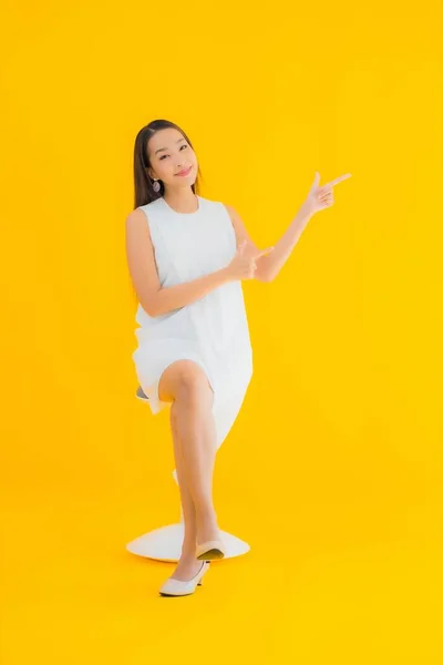 Portret Pięknej Młodej Azjatyckiej Kobiety Akcji Żółtym Odizolowanym Tle — Zdjęcie stockowe