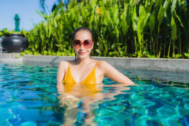 Güzel bir Asyalı kadın portresi. Rahatlayın. Keyifli bir tatil için oteldeki yüzme havuzunda mutlu bir gülümseme.