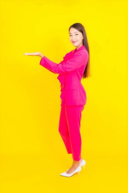 Güzel bir Asyalı kadın sarı arka planda gülümsüyor.