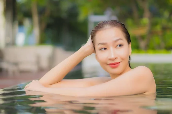 ポートレート美しい若いアジアの女性は休暇旅行でホテルのリゾートで屋外スイミングプールの周りの笑顔をリラックス — ストック写真