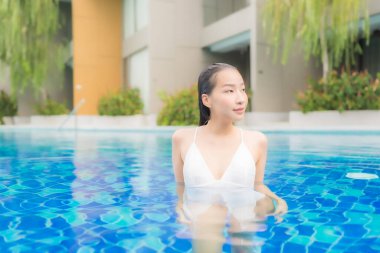 Güzel bir Asyalı kadın portresi. Rahatlayın. Yüzme havuzunda gülümseyin.