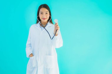 Klinikte ya da mavi izole edilmiş arka planda hastanede kullanmak üzere steteskoplu güzel Asyalı genç doktor kadın portresi.