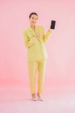 Güzel Asyalı iş kadını portresi. Arka planda kahve fincanı ve akıllı cep telefonu kullanıyor.