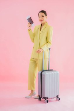 Güzel Asyalı iş kadını portresi, bavul çantası ve pasaport renginde.