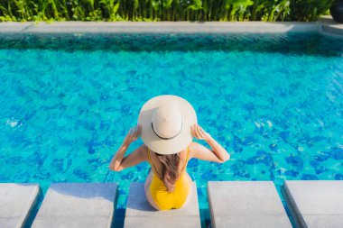 Güzel bir Asyalı kadın portresi. Rahatlayın. Keyifli bir tatil için oteldeki yüzme havuzunda mutlu bir gülümseme.