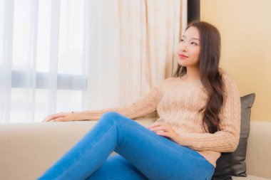 Güzel bir Asyalı kadın portresi rahatla. Gülümse. Yatak odasının iç dekorasyonunda mutlu ol.