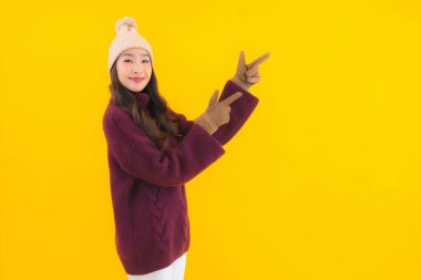 Güzel Asyalı kadın gülümsüyor. Sarı izole edilmiş arka planda başka bir eylemde mutlu.