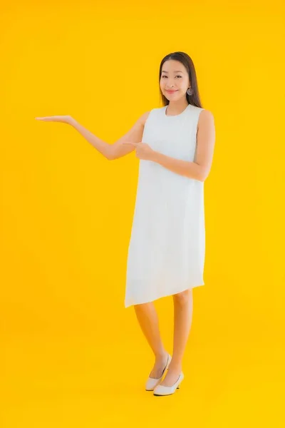 Portret Pięknej Młodej Azjatyckiej Kobiety Akcji Żółtym Odizolowanym Tle — Zdjęcie stockowe