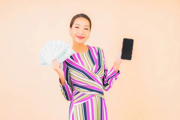 현금이나 아름다운 아시아 여성과 피부색이 배경에 핸드폰을 — 스톡 사진