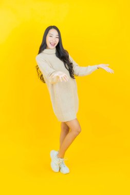 Portre güzel Asyalı kadın gülümsüyor. Renkli arka planda hareket var.