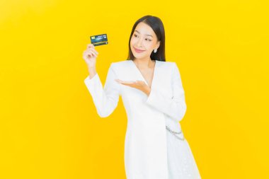 Güzel bir Asyalı kadının portresi. Renkli kredi kartıyla gülüyor.