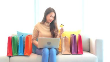 Evinden e-alışveriş yapan güzel Asyalı kadının görüntüleri.