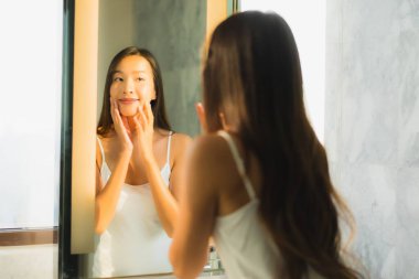 Güzel bir Asyalı kadın portresi. Banyo içinde yüzünü ve yüzünü kontrol et.