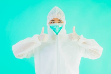 Güzel, genç Asyalı doktor kadın portre. Koronavirüsten ya da mavi arka planda kovid19 'dan korunmak için ppe ya da kişisel koruyucu ekipman takıyor.