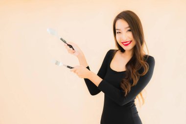 Kaşığı ve çatalı olan güzel Asyalı bir kadının portresi izole edilmiş renkli arka planda yemeye hazır.