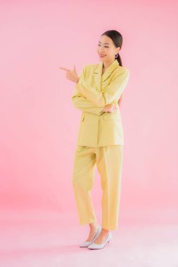 Portre güzel Asyalı genç iş kadını pembe arka planda gülümsüyor