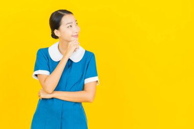 Güzel bir Asyalı kadın portresi ve sarı arka planda hareketli bir gülümseme.