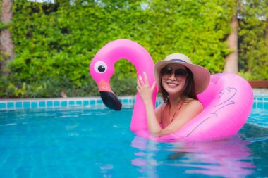 Portre genç Asyalı kadın rahatla otel havuzunda yüzme havuzunda mutlu bir gülümseme