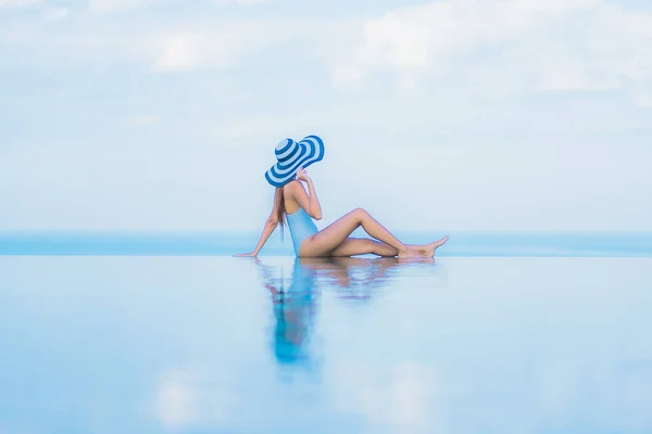 美丽动人的年轻亚洲女人在酒店度假胜地近岸的海滨游泳池边放松地笑着 — 图库照片