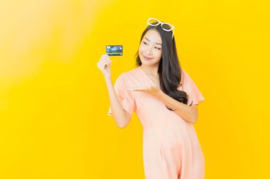 Güzel bir Asyalı kadının portresi. Renkli kredi kartıyla gülüyor.